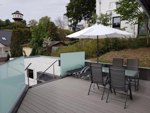 a table and chairs with an umbrella on a deck at Ferienanlage Mönchgut, Ferienhaus Mönchgut in Göhren
