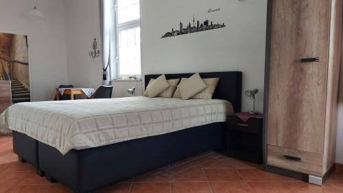 Un dormitorio con una cama con marco negro. en Leipzig Ferienwohnung in ruhiger Lage, en Leipzig