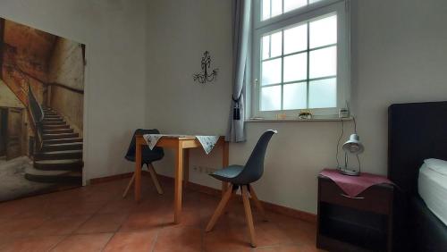 una sala de estar con una mesa y dos sillas en Leipzig Ferienwohnung in ruhiger Lage, en Leipzig