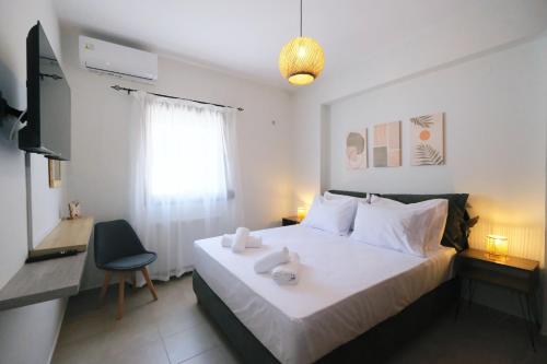 a bedroom with a bed with a desk and a television at Nerea Apartments in Agios Ioannis Kaspaka