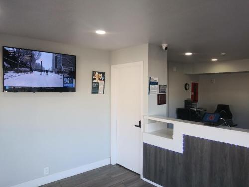 a waiting room with a flat screen tv on the wall at Studio 6 West Sacramento CA in West Sacramento