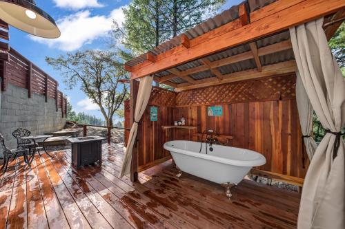 baño con bañera en una terraza de madera en Mays Luxury Farmstay, en Los Gatos