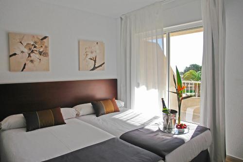 Un dormitorio con una cama grande con ventana. en Palmera Beach, en Pilar de la Horadada