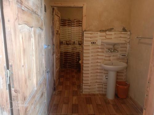 a small bathroom with a sink and a shower at Karam Siwa Camp in Siwa