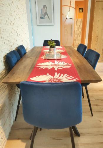 a wooden table with blue chairs and a red table cloth at Pintelie - für 2-6 Personen in Sankt Englmar