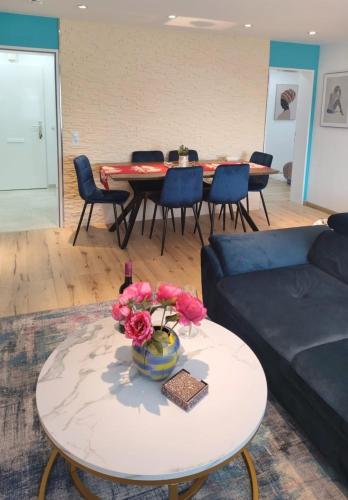 a living room with a couch and a table with flowers at Pintelie - für 2-6 Personen in Sankt Englmar