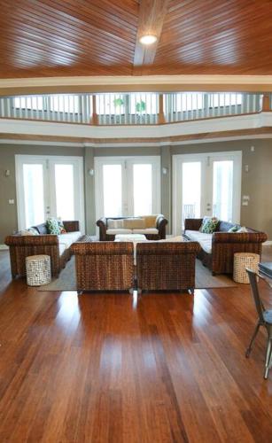 a large living room with couches and tables and windows at Chateau on Colony Cove in Dauphin Island