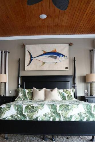 a bedroom with a bed with a fish painting on the wall at Chateau on Colony Cove in Dauphin Island