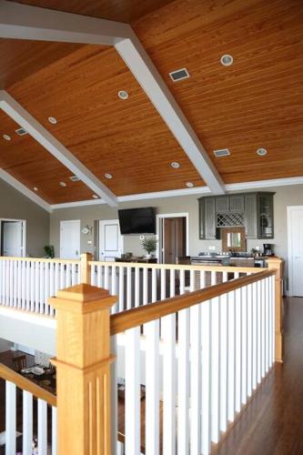 a staircase in a house with a wooden ceiling at Chateau on Colony Cove in Dauphin Island