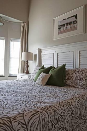 a bedroom with a large bed with green pillows at Chateau on Colony Cove in Dauphin Island