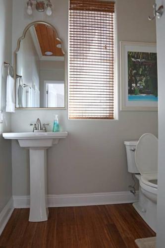 a bathroom with a sink and a mirror and a toilet at Chateau on Colony Cove in Dauphin Island