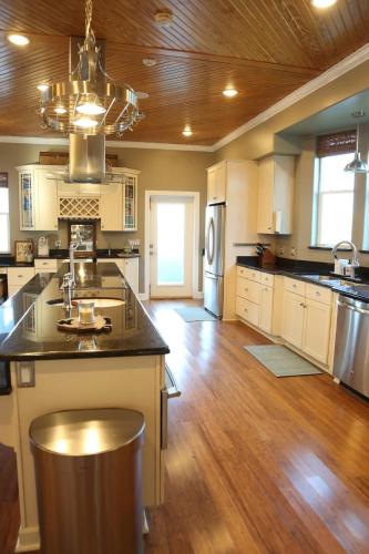 a large kitchen with white cabinets and a wooden ceiling at Chateau on Colony Cove in Dauphin Island