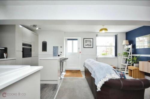 a kitchen with white counters and a couch in a room at Dog friendly Beach Apartment in Broadstairs