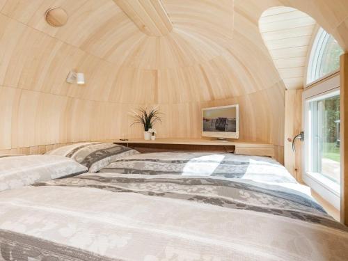 a large bed in a room with a large window at Tinyhouse 2 in Heringsdorf