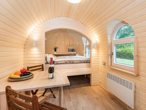 a room with a bed and a table with a bottle of wine at Tinyhouse 2 in Heringsdorf