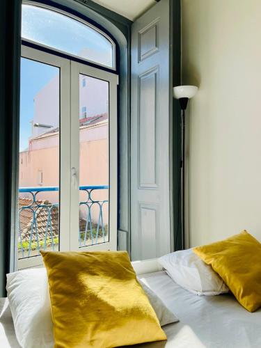 a bedroom with a bed and a large window at Spacious T4 Central Apartment with Iconic Tram 28 View in Lisbon