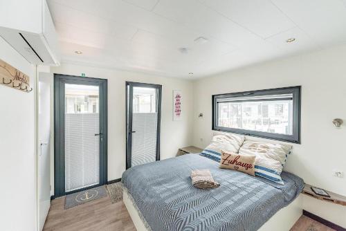 a bedroom with a bed and a window at Hausboot Achat in Zehdenick