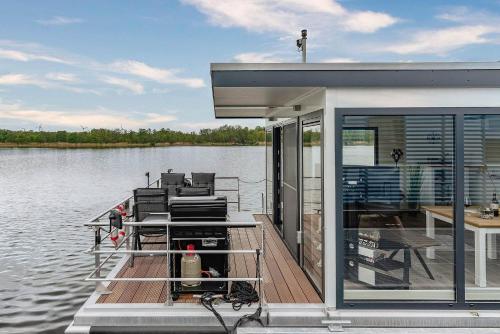 a house on a dock on a body of water at Hausboot Achat in Zehdenick