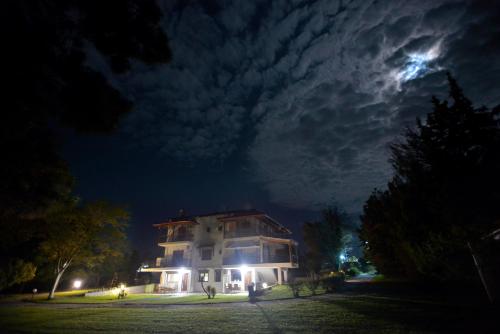 a house at night with the moon in the sky at Theros-Cottage in Siviri
