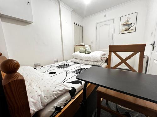 a small room with a bed and a table at Budget Stay In Luton 01 D in Luton