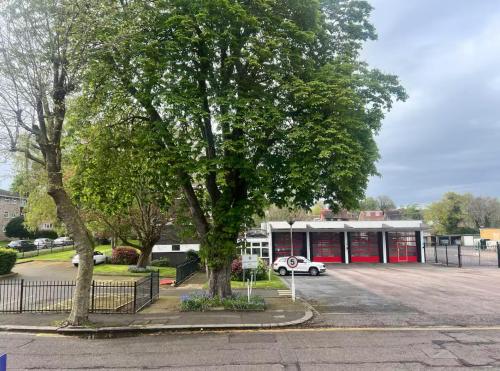 a tree in a parking lot in front of a building at Budget Stay In Luton 01 D in Luton