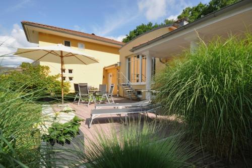 een huis met een patio met een parasol en stoelen bij Ferienhaus Marina in Soltau