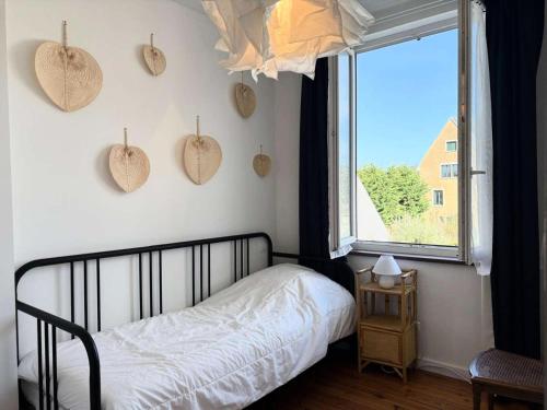 - une chambre avec un lit et une fenêtre avec des coeurs sur le mur dans l'établissement Résidence G78-tregastel - Maison avec jardin près du Coz Pors à Trégastel MAE-3574, à Trégastel