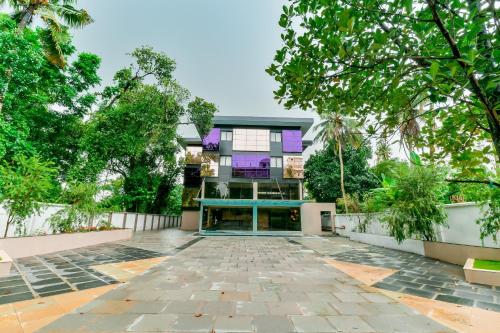 an empty courtyard in front of a building with trees at Townhouse Edassery Blue Bells in Cochin