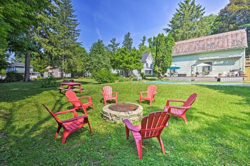 a group of red chairs sitting around a fire pit at Walkable Studio on Historic Hammondsport Property! in Hammondsport