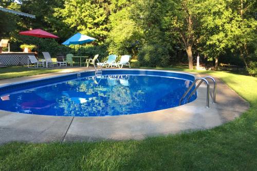 a swimming pool in a yard with chairs and umbrellas at Walk to Eats Mtn-View Hammondsport Hideaway! in Hammondsport