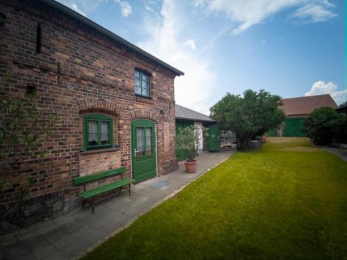 a brick building with a green door and a bench at Spreewälder Schwalbenhof - Ferienwohnung "Storchennest" in Golßen