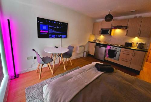 Una sala de estar con una mesa y una cocina. en Modern studio apartment in Gunwharf, en Portsmouth