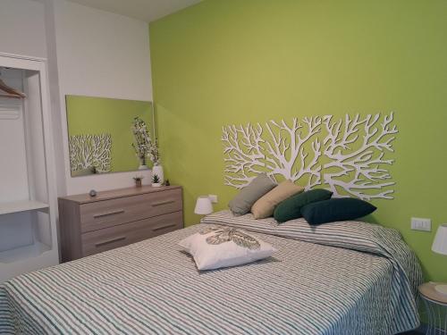 a bedroom with a bed with a painting on the wall at Appartamento Mare Verde Bambù in Martinsicuro