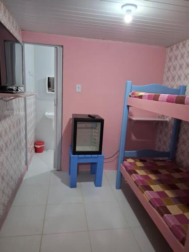 a room with a bunk bed and a tv on a table at Hostel & Pousada UFPE INN in Recife