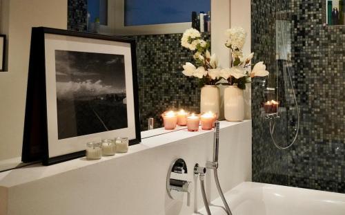 a bathroom with candles on a shelf above a bath tub at LAKEVIEW - a design holiday home in Berlingen