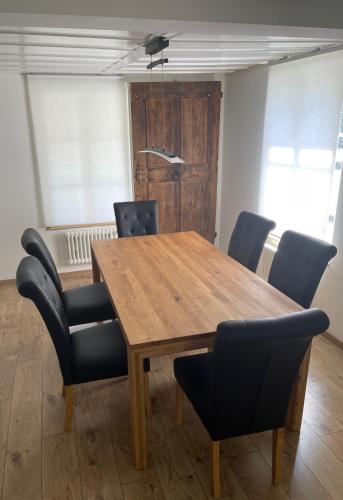 a wooden table and chairs in a room at Grosse Neue Wohnung in Bern mit Whirlpool in Bern