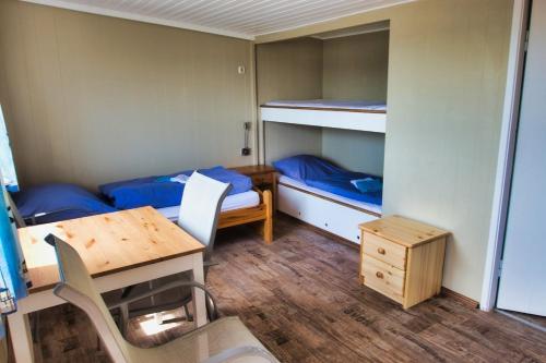 a small room with two bunk beds and a table at Finnenhaus 4 in Lübeck