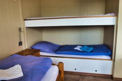 two bunk beds with blue sheets in a room at Finnenhaus 4 in Lübeck