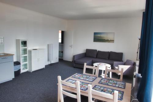 a living room with a couch and a table and chairs at Alte Segelschule in Lübeck