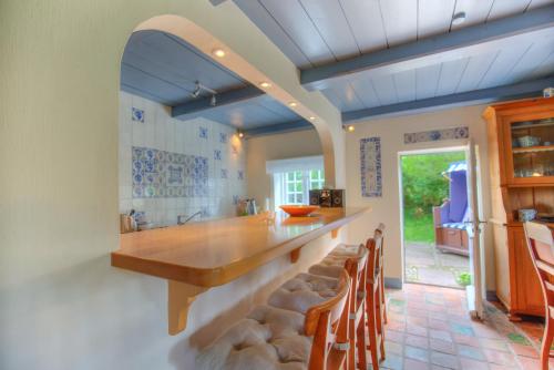una cucina con un grande bancone in legno e sedie di S1 im Friesenhaus Sara a Wenningstedt