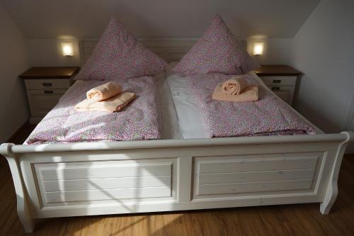 a white bed with pink pillows on it at Nordlicht II in Trent