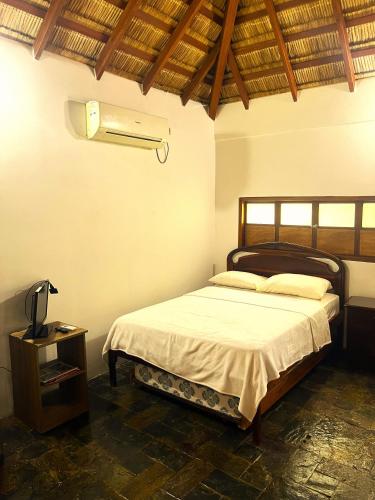 a bedroom with a bed and a air conditioner at Muyuyo Lodge in Ayangue