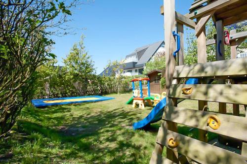 a yard with a playground with a slide at Abaluga 4A in Wenningstedt
