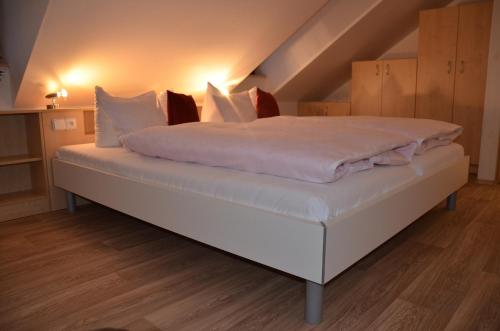 a bed with white sheets and pillows in a room at Apartment U Karla in Třeboň