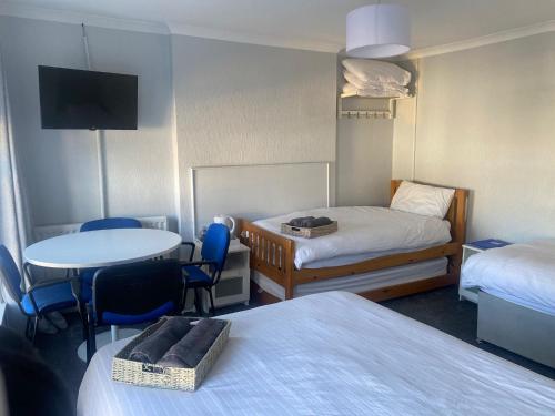 a hotel room with two beds and a table and chairs at Railway Bar Accommodation in Poyntz Pass