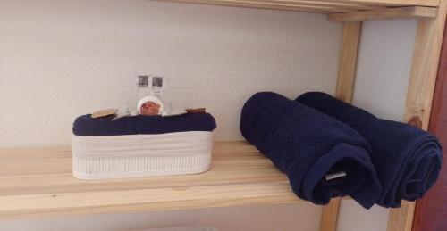 Un estante con dos toallas y una botella. en Casa Lua, en Isla de Boipeba