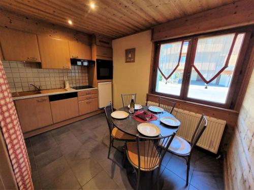 une cuisine avec une table et des chaises dans une pièce dans l'établissement Résidence Beau Sejour - Appartement confortable, idéal pour des vacances en famille MAE-5231, aux Gets