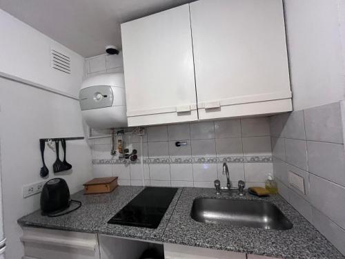 a small kitchen with a sink and white cabinets at Loft plaza España in Mendoza