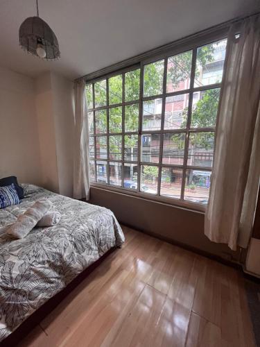 a bedroom with a bed and a large window at Loft plaza España in Mendoza
