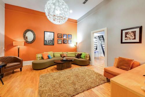 a living room with a green couch and an orange wall at Historic Decatur Apt with City Square Views in Decatur